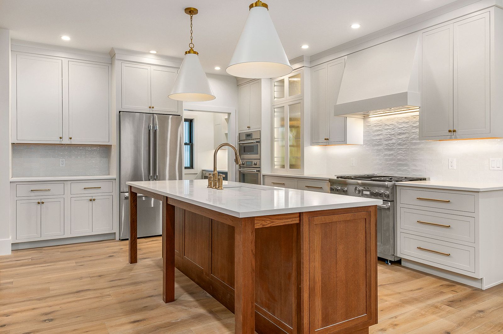 Kitchen with a walnut island, plaster range hood and professional stainless range - a River Birch Builders home in the New Hampshire Seacoast